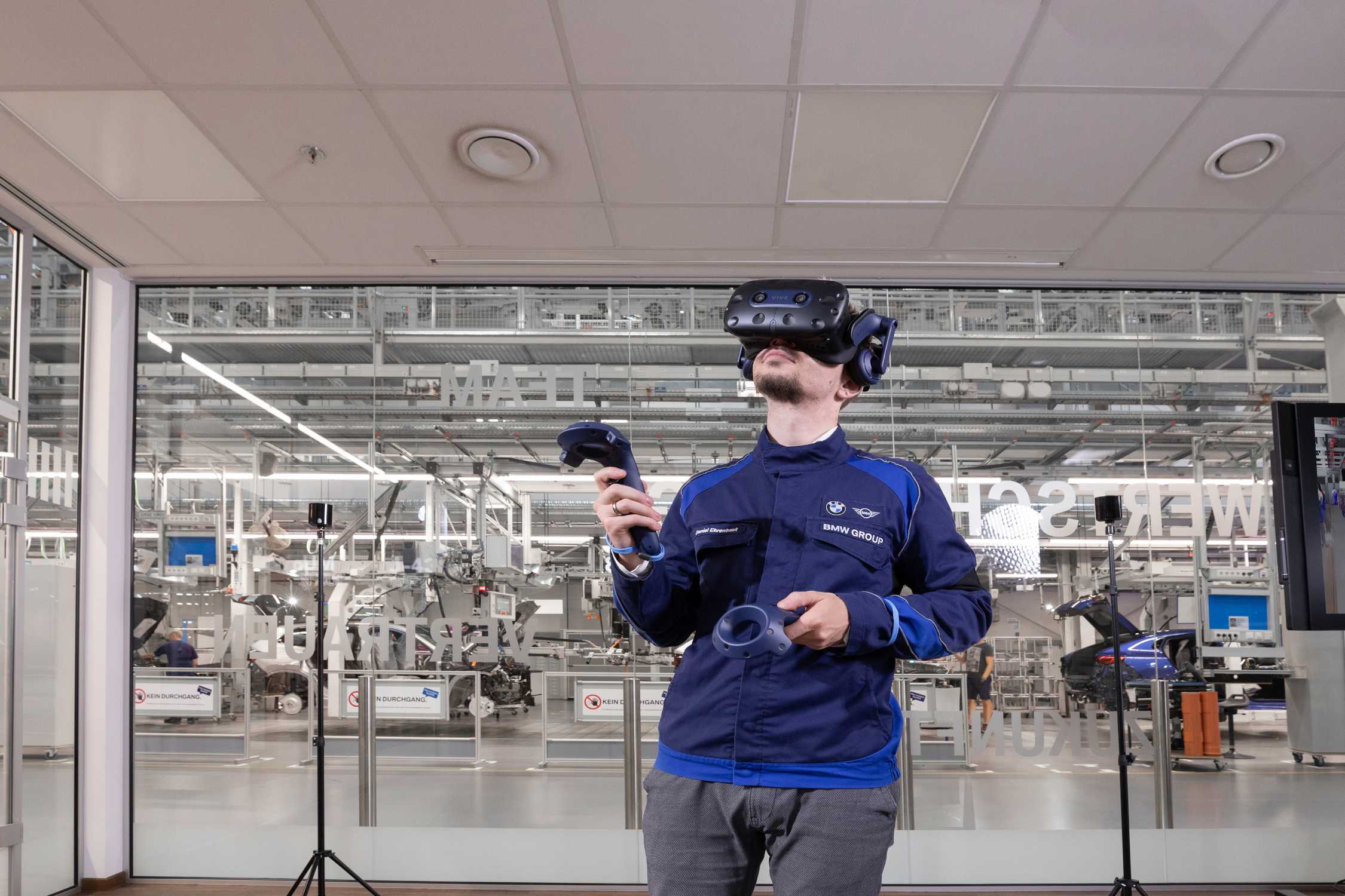 Innovative 3D Mensch-Simulation im BMW Group Werk Regensburg: Mitarbeiter erkundet durch VR-Brille das künftige Fabriklayout in virtueller Umgebung. (07/2024)